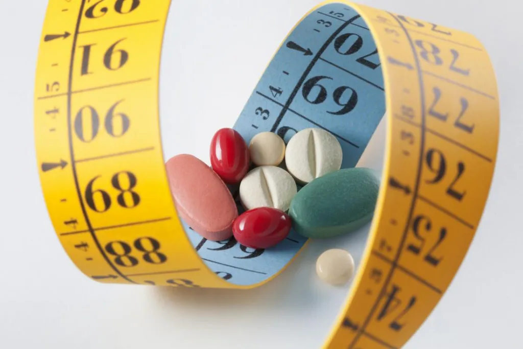 weight-loss-and-blue zone diet-pills-surrounded-by-measuring-tape