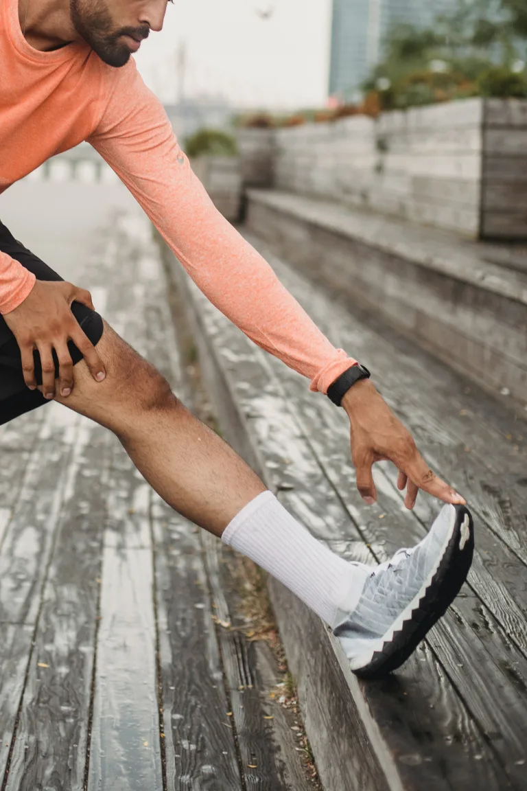 Close up photo of a man stretching his foot on the stairs-detraining