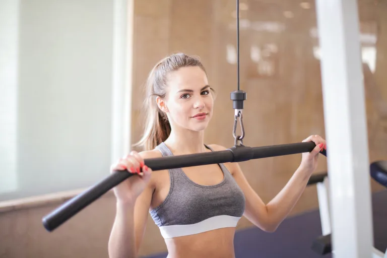 fit woman wearing gray tank tops doing pull ropes workout in the gym - superfoods low-carb