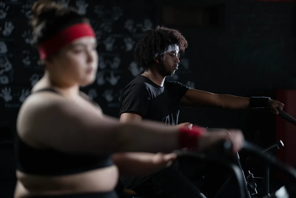 man and overweight woman exercising in stationary bike