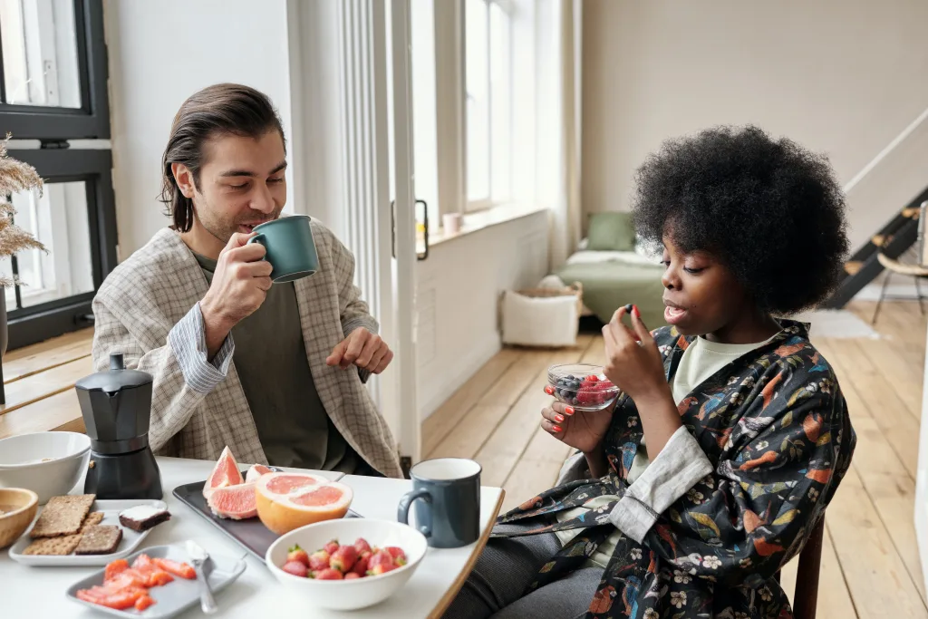man and woman having healthy breakfast drinking water