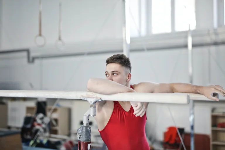 Photo of man resting in steel bar after intense training