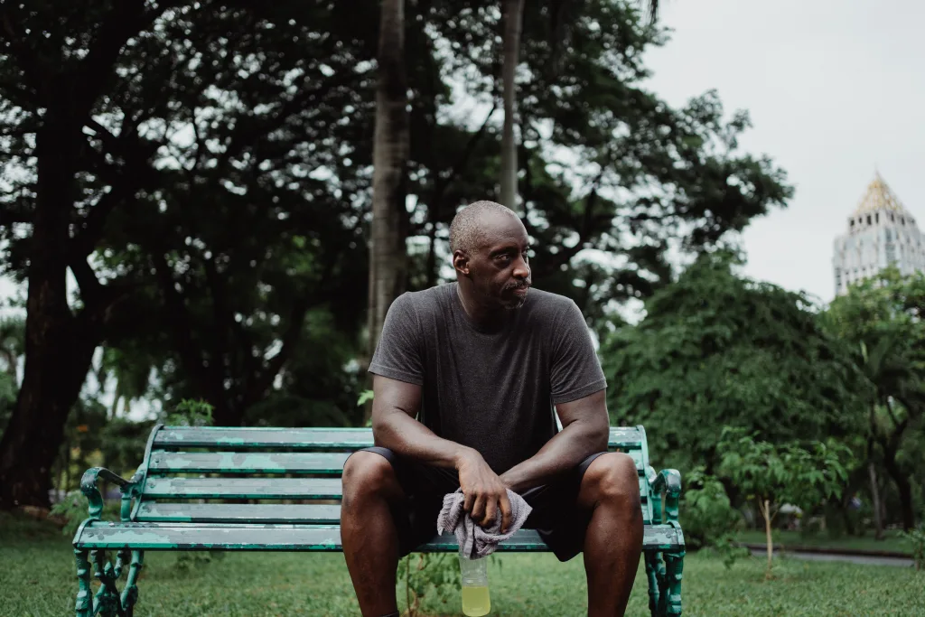 Tired man is resting on the bench after exercise - inactive men