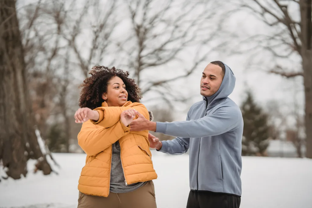 man teaching woman the correct for of stretching