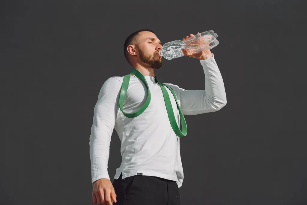 man wearing white long sleeves drinking water hcg injection