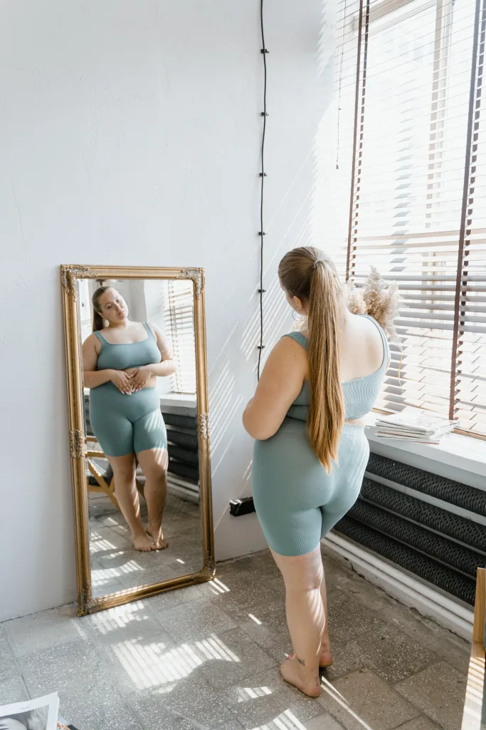 overweight woman watching herself in the mirror with obesity