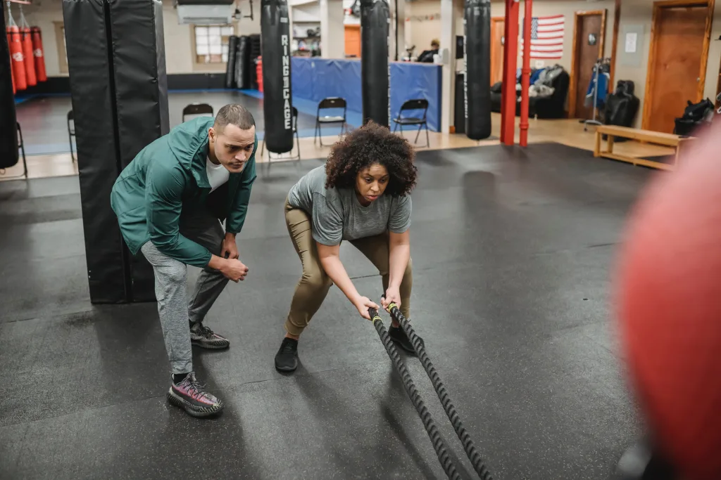 overweight woman holding battle ropes for preventing obesity