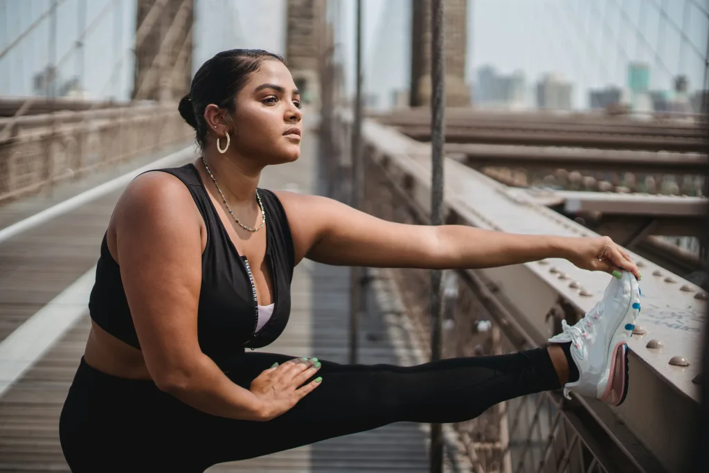 overweight woman stretching on the bridge