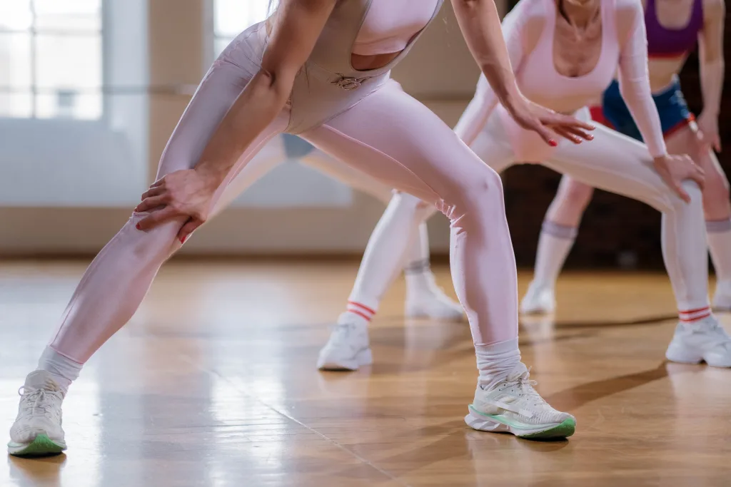 people in aerobics stretching to avoid leg problems