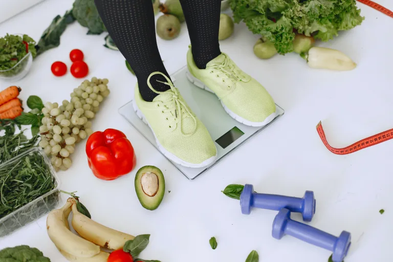 different type of healthy food with infused water and a person standing on a weighing scale superfood