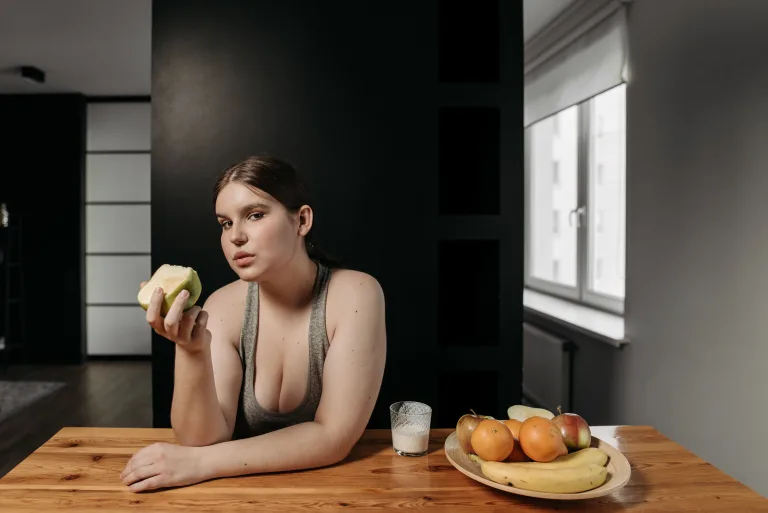 Serious woman eating at the table fasting