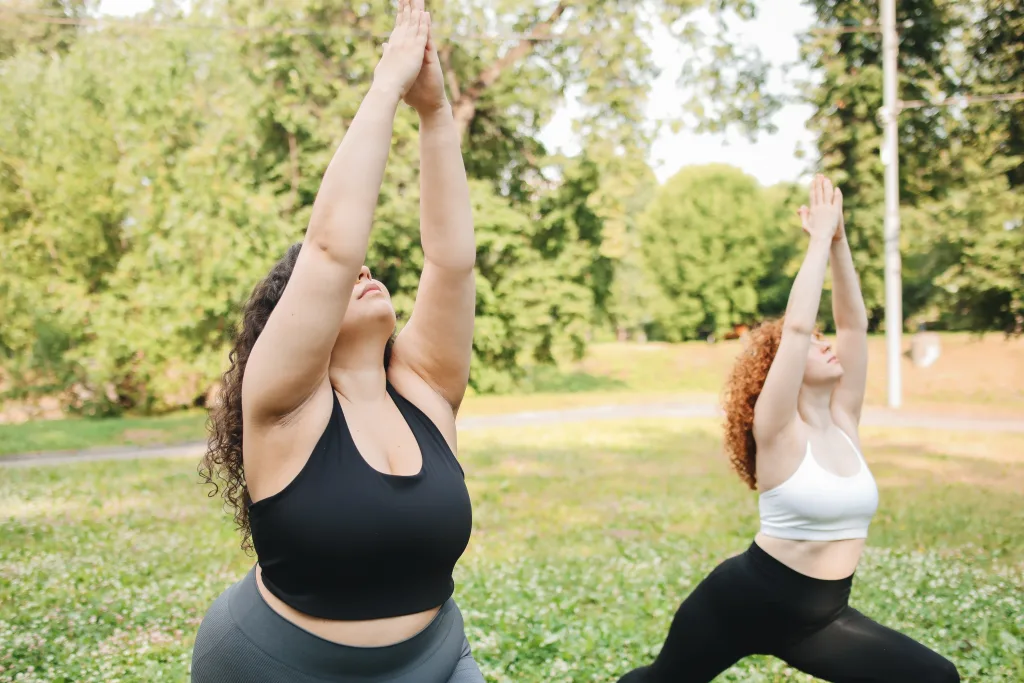 two women with different body type doing yoga outdoors-slim-shots