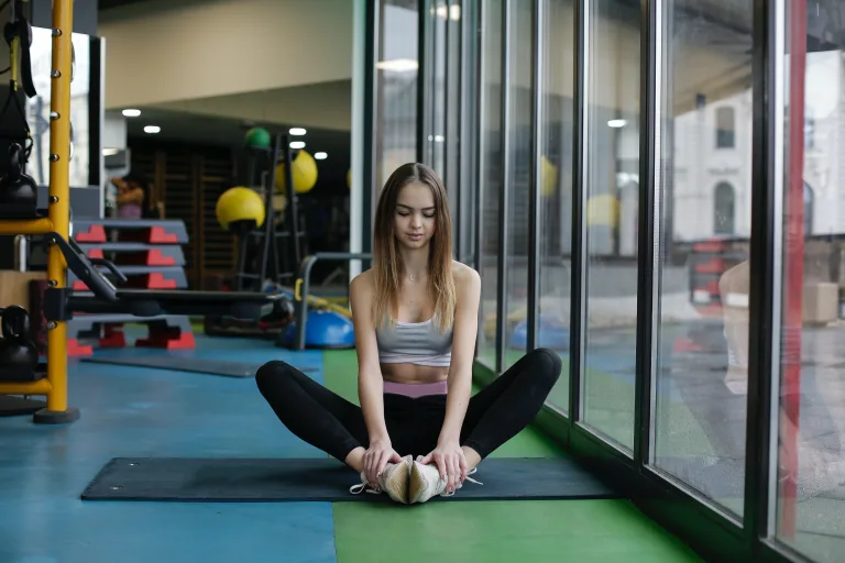 nutty-slim woman sitting on yoga mat near window weight loss