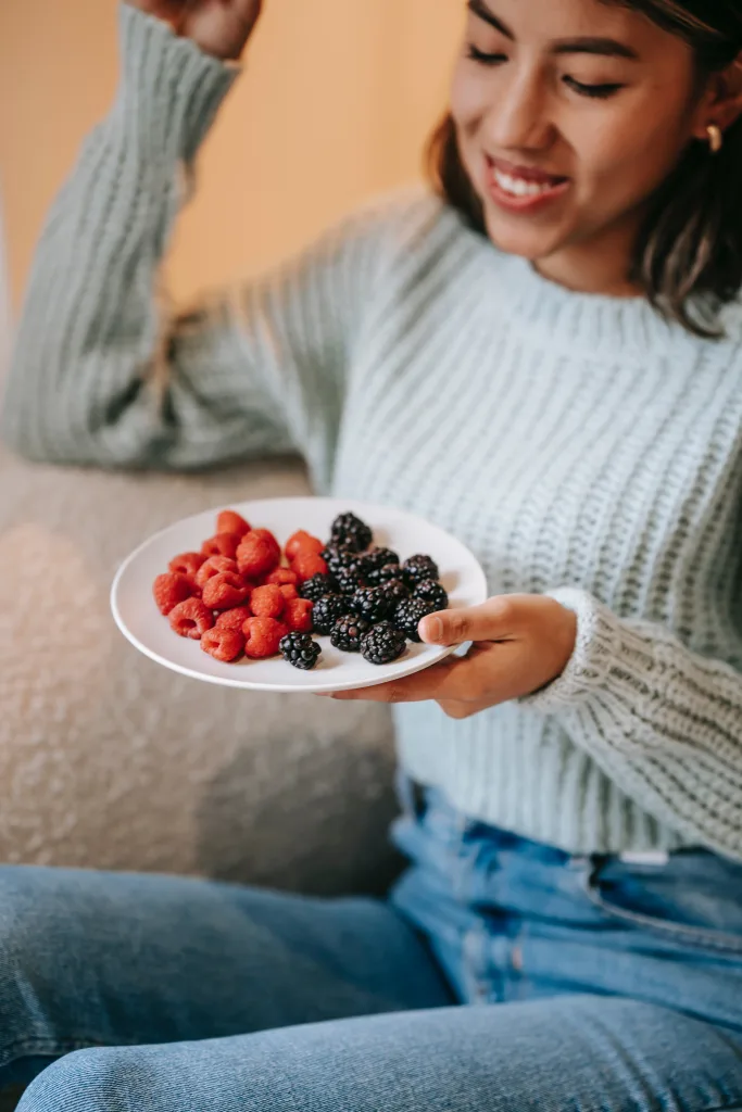 smiling woman eating fresh berry