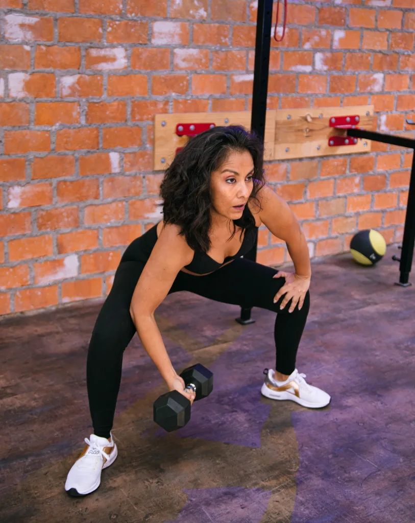 strong woman lifting dumbbells for curing high blood pressure