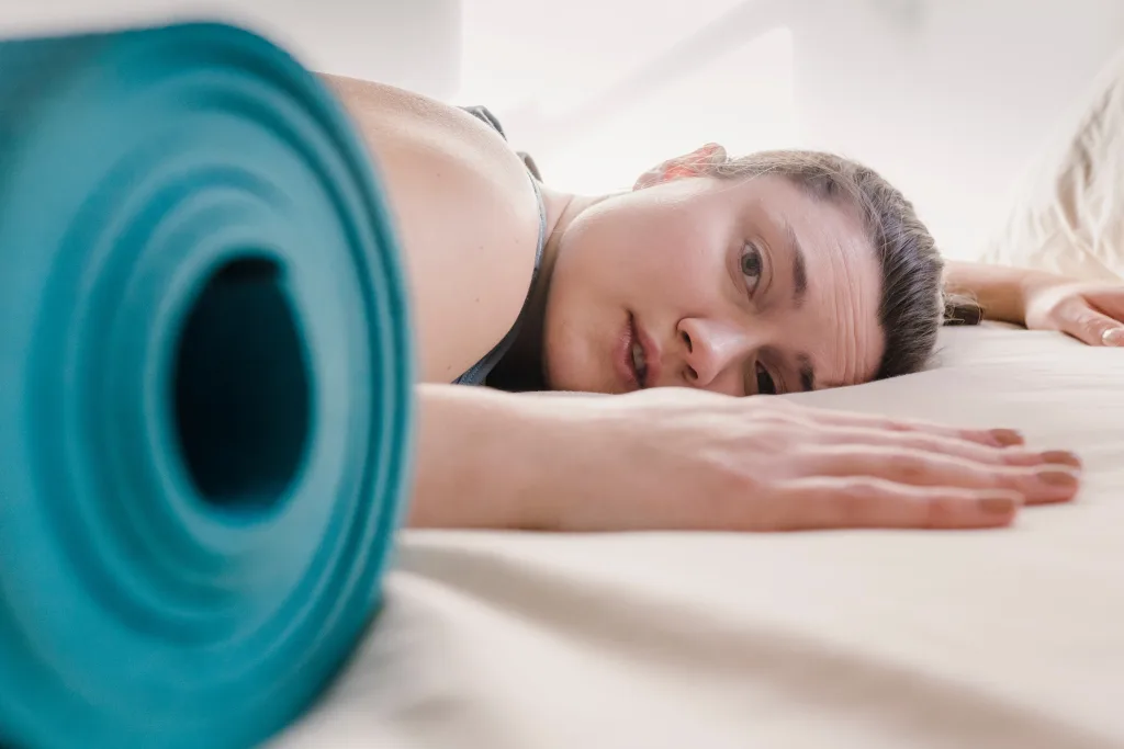 Drained woman lying on the bed after extreme exercise