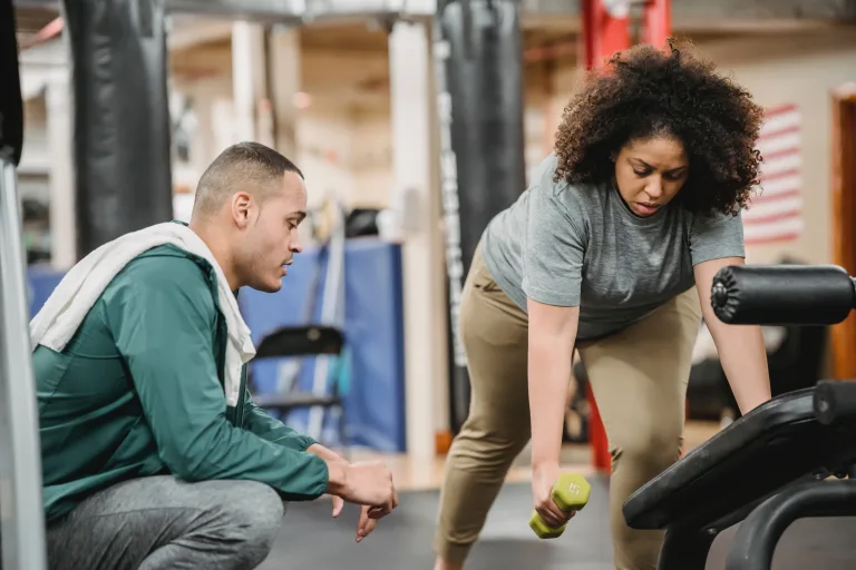 trainer teaching the correct way to exercise to a woman ac joint exercises