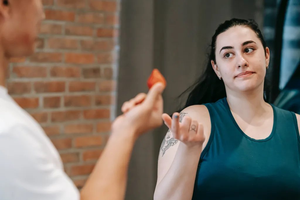trainer offering strawberry to woman