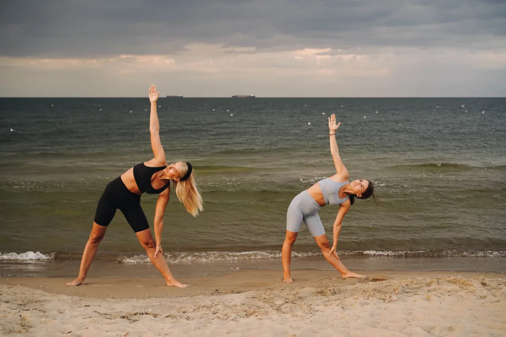 two women exercising at the beach to avoid obesity