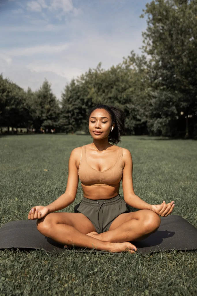 Fit woman meditating under the sun