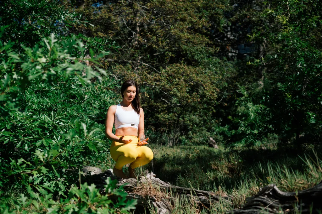woman meditating near river