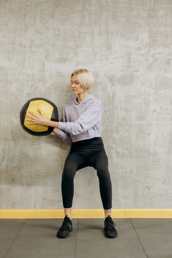 woman working out with  low-impact exercises ball