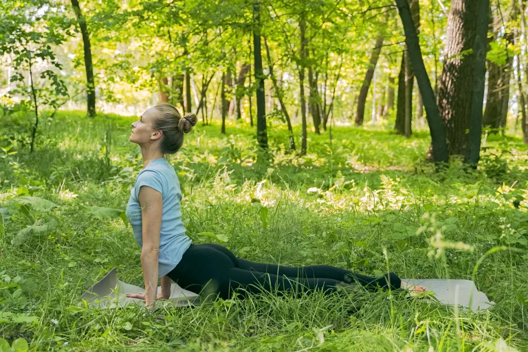 woman doing yoga on green grass blue zone diet
