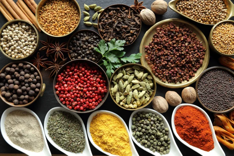 Herbs, chili peppers and spices composition. Cooking ingredients on a ceramic tabletop.