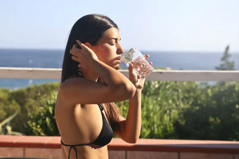 fit woman drinking water before eating good for appetite
