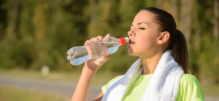 woman drinking more water after exercising