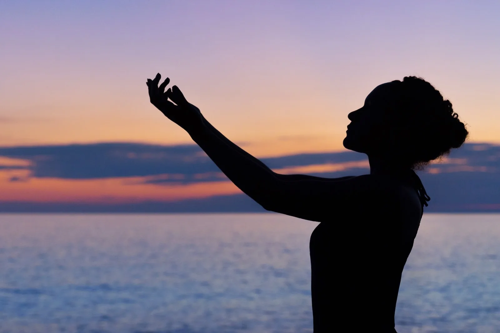 silhouette of woman raising her right hand fasting for weight loss