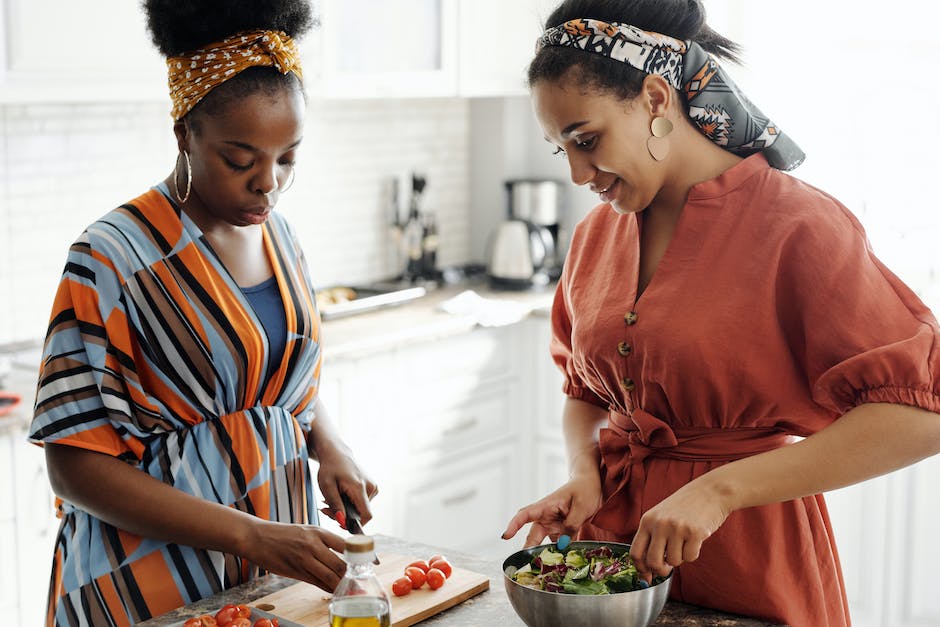 A woman preparing a colorful salad with various vegetables, representing a low carb diet.