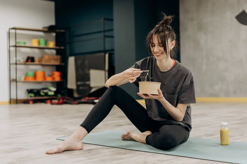 woman sitting on yoga mat eating healthy meal